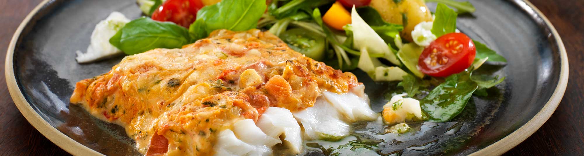 Ugnsbakad fiskfilé med tomatsås, potatis och sallad